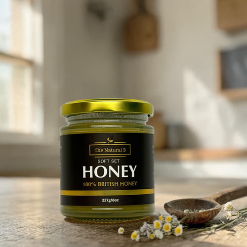 Jar of honey with a label on a wooden surface in a kitchen setting