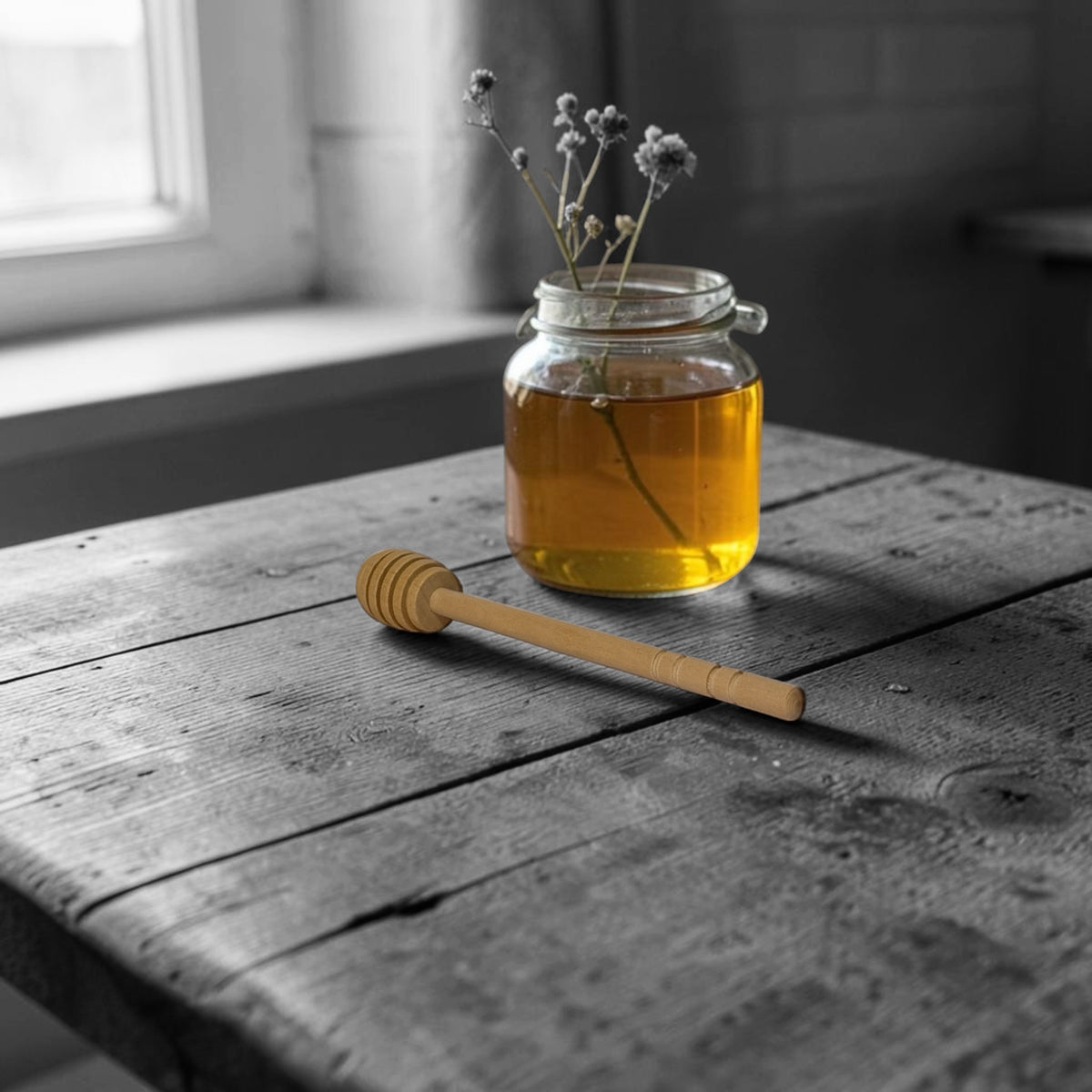Jar of honey with a wooden dipper on a wooden table